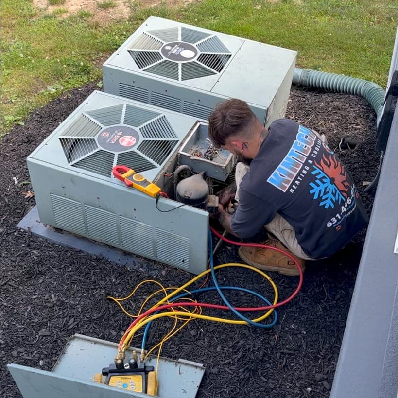 Kintech technician repairing a central air conditioning condenser