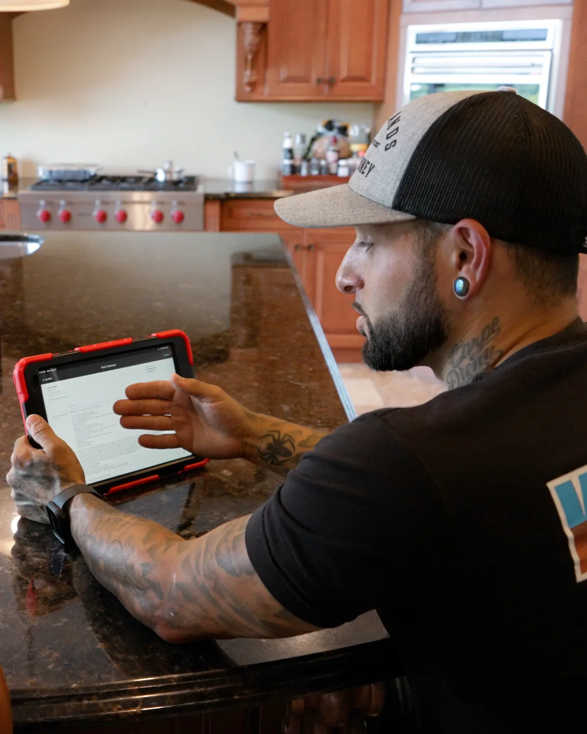 A Kintech technician going over an estimate on a tablet at a customer's kitchen island