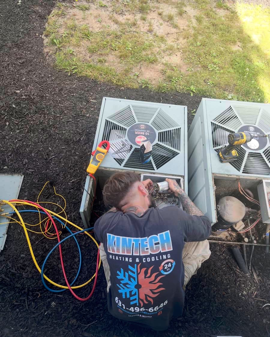 Kintech technician servicing two central air condenser units