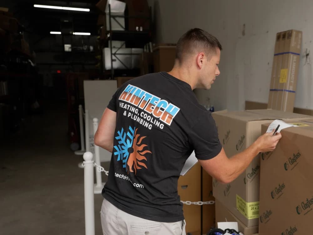 A Kintech technician checking equipment labels in the warehouse