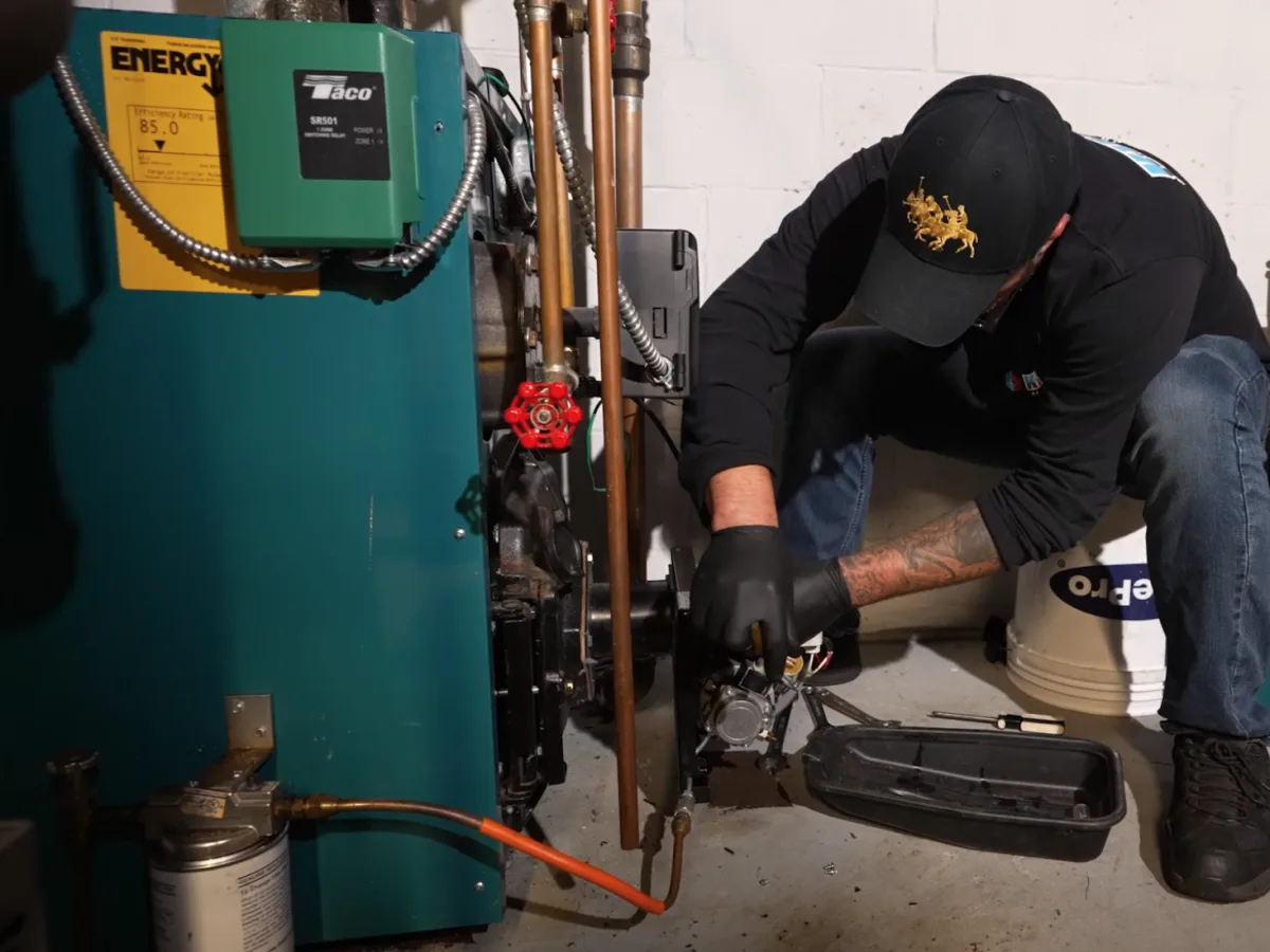 A Kintech technician servicing the burner of an oil-fired boiler