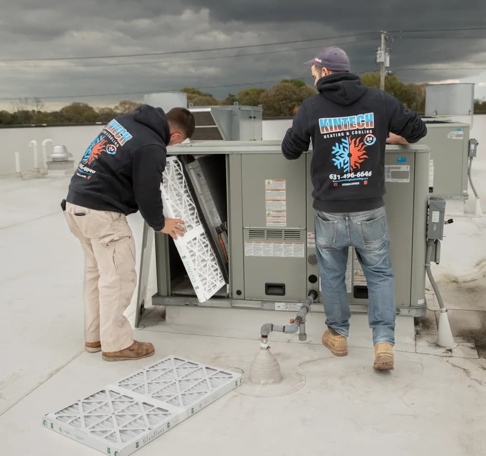 Two Kintech technicians changing the filters in a rooftop unit