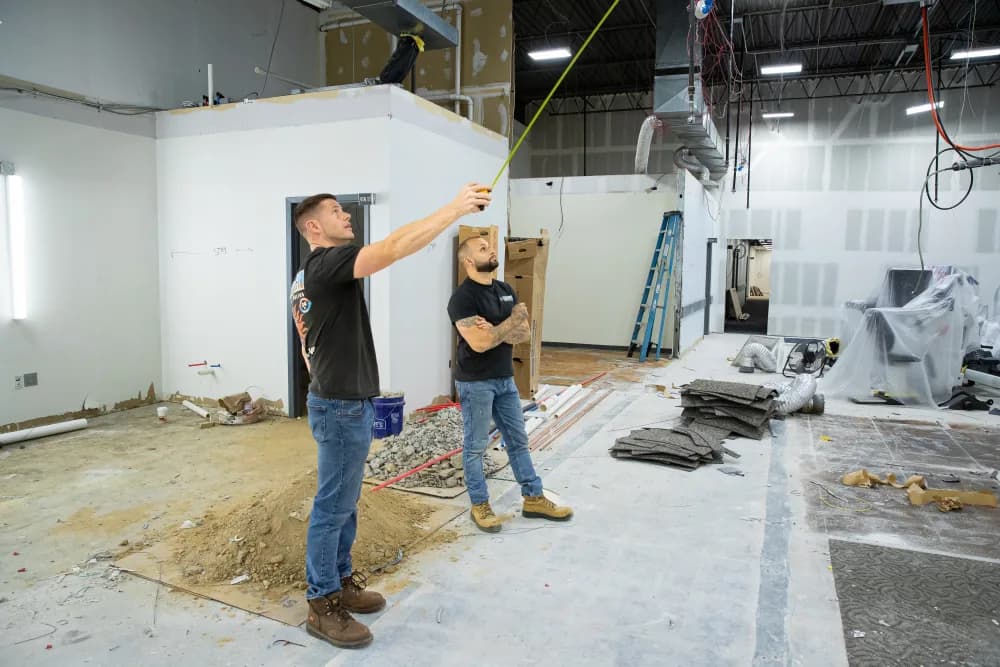 Two Kintech technicians measuring out a commercial build-out